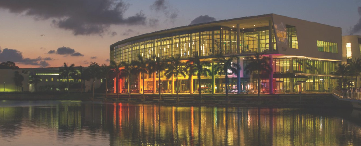 text "Where U Belong" over photo of Shalala Student Center lit up by rainbow lights