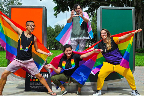 LGBTQIA+ student organization members pose in front of the U statue