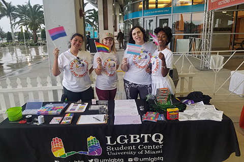 LGBTQ student  center student workers pose at tabling event